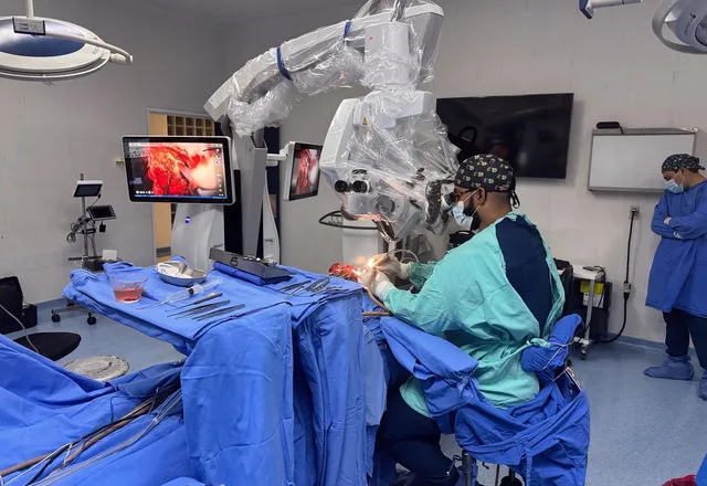 Dr. Edgardo Mateo operando con microscopio quirúrgico una lesión de base de cráneo, neurocirujano en República Dominicana